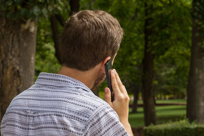 Rear view of man using mobile phone