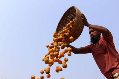 Low angle view of man working against clear sky