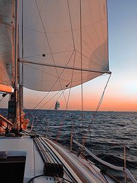 Boats in sea at sunset