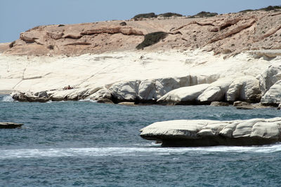 Scenic view of rocks in sea against sky