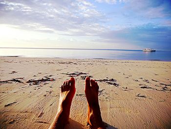 Low section of man relaxing on beach