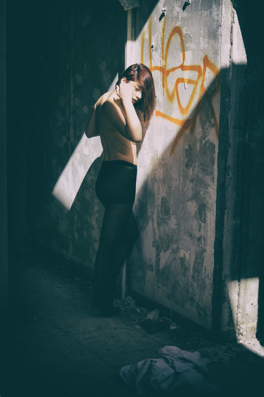 full length, graffiti, one person, young adult, beauty, standing, one woman only, beautiful woman, young women, one young woman only, indoors, only women, adult, day, people, adults only