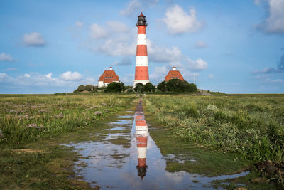 View of lighthouse amidst field against sky