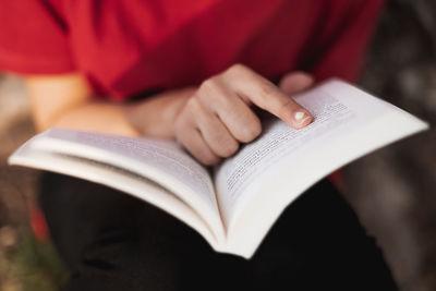 Midsection of woman reading book