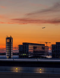 Buildings in city against sky at sunset