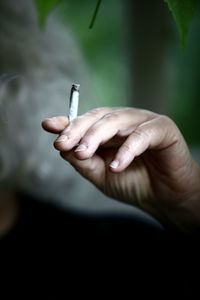 Close-up of hand holding cigarette