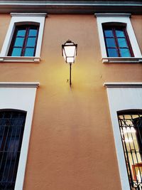 Low angle view of illuminated street light against building