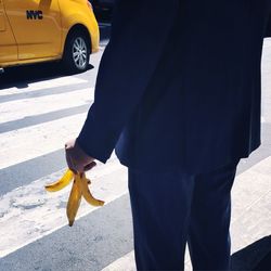 Low section of man standing on sidewalk