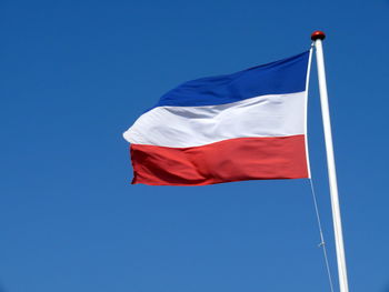 Low angle view of dutch flag against clear blue sky