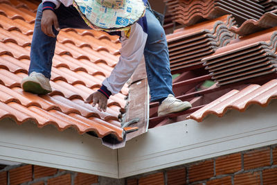 Low angle view of man working on roof of building