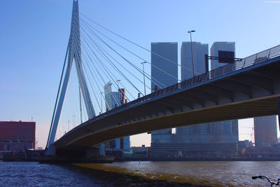 Low angle view of bridge over river against sky in city