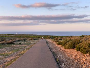 Road leading towards sea against sky