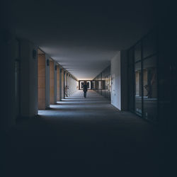 Rear view of man walking in building passage