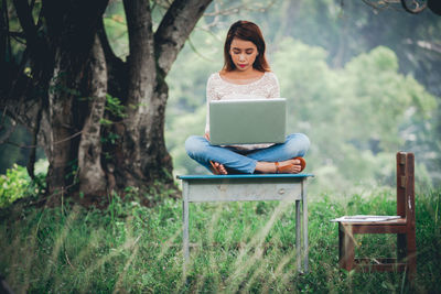 Woman sitting on bench in park