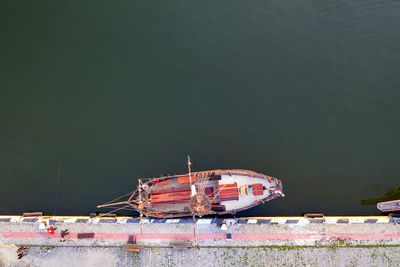 Aerial top view by drone of the moored small vintage ship at the quay. parking