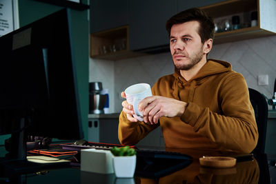 Tired man works late at workplace, use computer