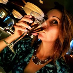 Close-up portrait of a young woman drinking glass