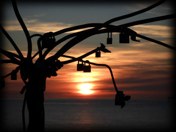 Close-up of silhouette metal against sky during sunset