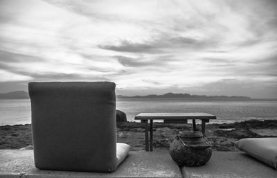 Close-up of table on beach against sky