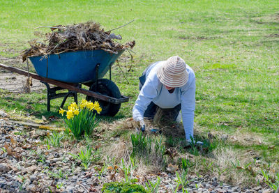 Senior woman weeding a flower bed in the springtime