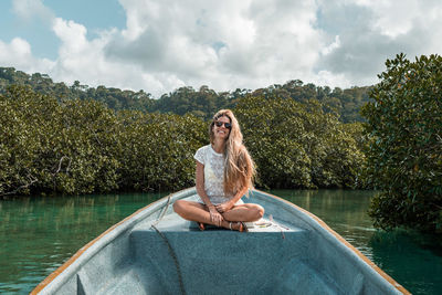 Portrait of young woman sitting on boat in lake