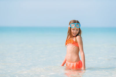 Full length portrait of woman in water at beach