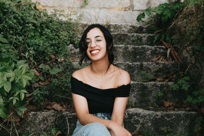 Portrait of young woman standing against wall