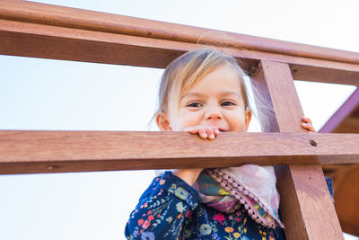 Portrait of smiling girl standing against railing