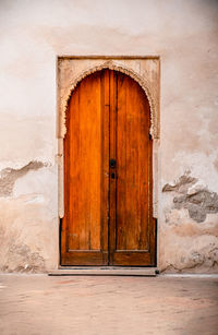 Wooden arched door at the alhambra. it highlights moorish craftsmanship and historical richness.