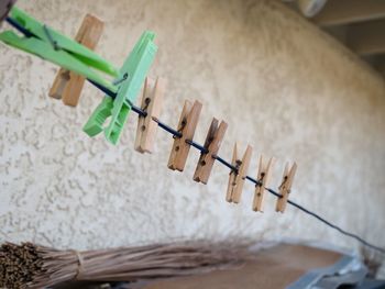 Close-up of clothespins on table against wall at home