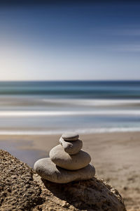 Pebble stack at beach against sky