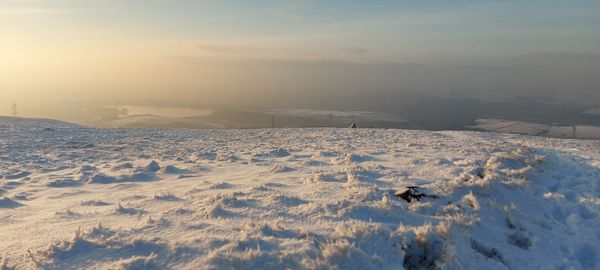 Scenic view of snow covered field against sky