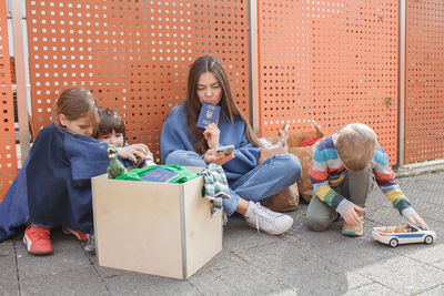 Side view of friends sitting on street