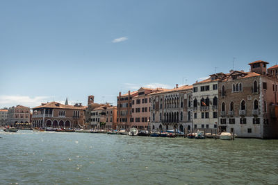 Buildings by sea against clear sky