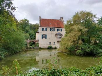 Building by lake against sky