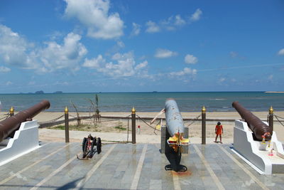 People at sea shore against sky