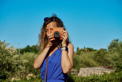 Young woman photographing through camera