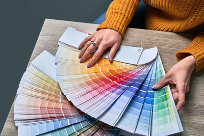 Midsection of woman holding color swatch at home