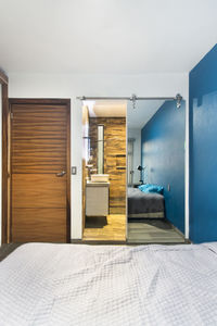 Bedroom, room, in the background you can see a bathroom, with mirrored sliding door, wooden door