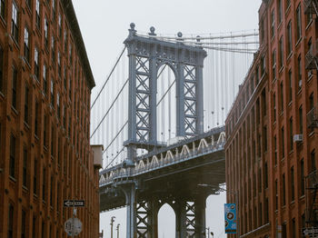 Low angle view of suspension bridge in city