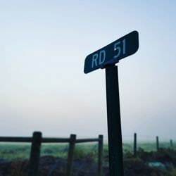 Close-up of road sign against sky