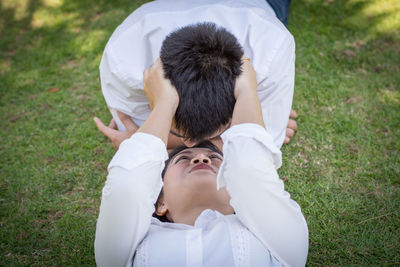 Rear view of father and son on grass