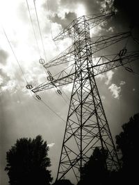 Low angle view of electricity pylon against cloudy sky