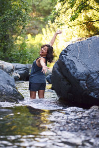 Young woman in a mountain river. she cools off after a day of hiking.