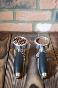 Close-up of coffee in portafilters on wooden table