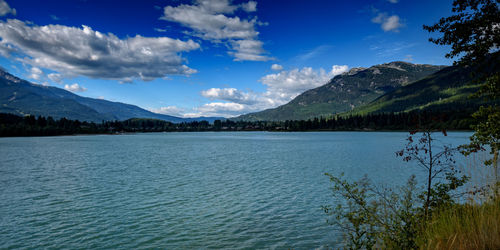 Scenic view of lake and mountains against blue sky