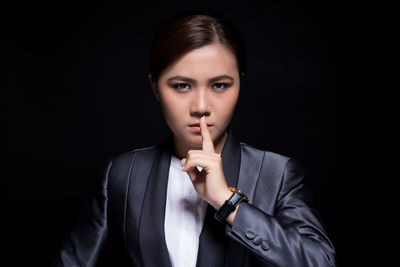 Portrait of a beautiful young woman over black background