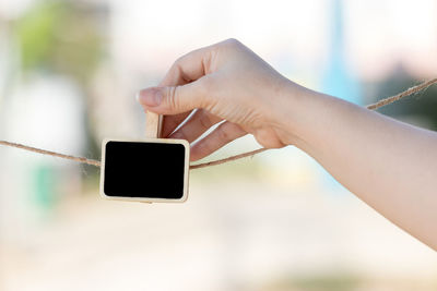 Close-up of woman photographing with mobile phone