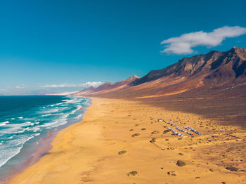 Scenic view of beach against blue sky