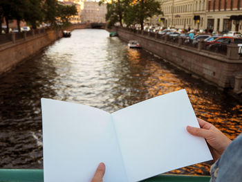 Reflection of person on book in canal